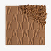 Der Bronzer Bronze Venus von Mesauda Beauty mit eingeprägtem M-Muster, die obere, rechte Ecke ist in losem Puder zerkleinert dargestellt.