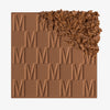 Der Bronzer Bronze Venus von Mesauda Beauty mit eingeprägtem M-Muster, die obere, rechte Ecke ist in losem Puder zerkleinert dargestellt.
