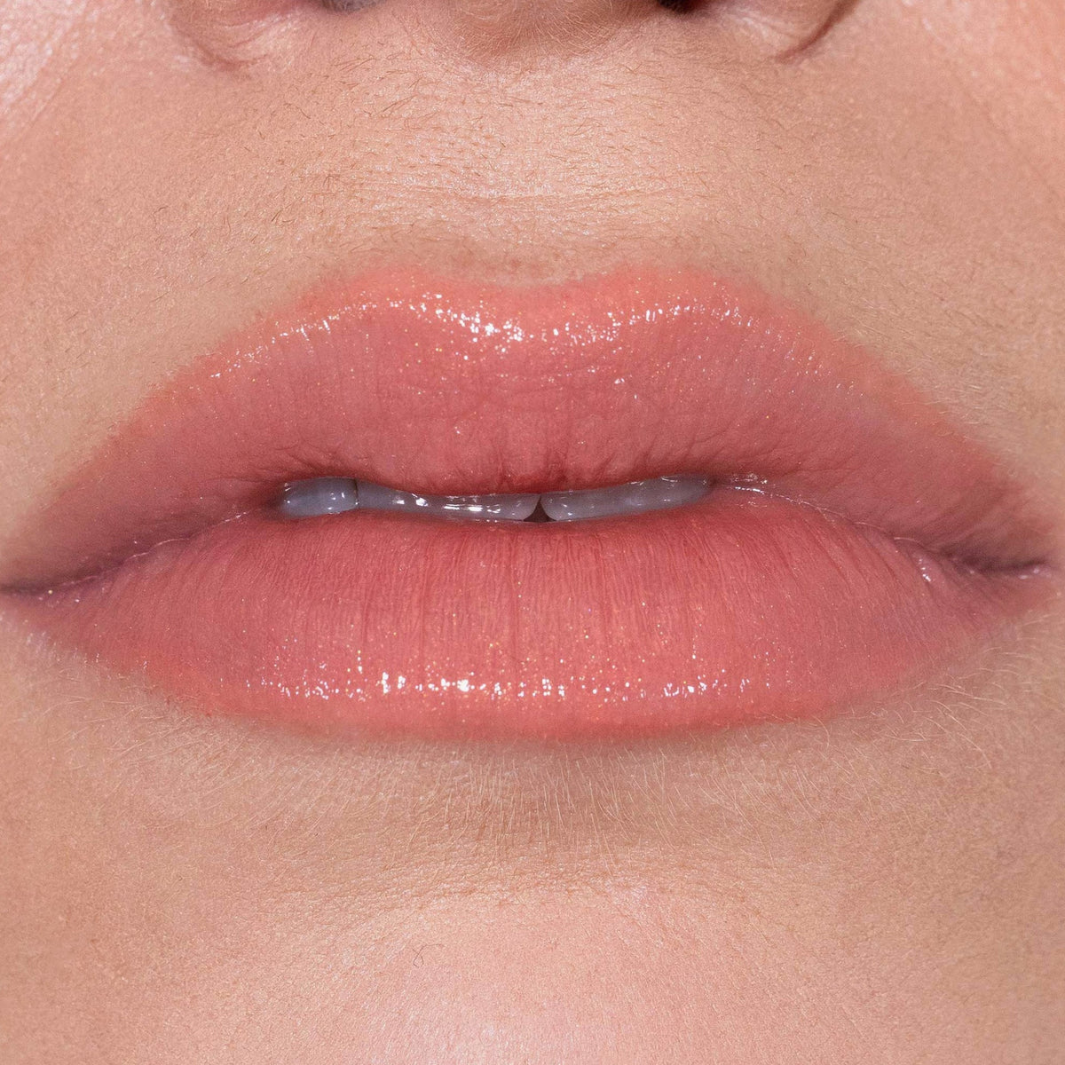 Nahaufnahme von glänzenden, nudefarbenen Lippen mit dem Fantastick Lipstick Sunstone von LH Cosmetics.