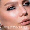 Nahaufnahme einer Frau mit auffälligem Make-up, Lidstrich und nudefarbenen Lippen, kreiert mit dem Crayon Lipliner Mellow Mauve von LH Cosmetics. Text: Lips | Eyes | Cheeks.