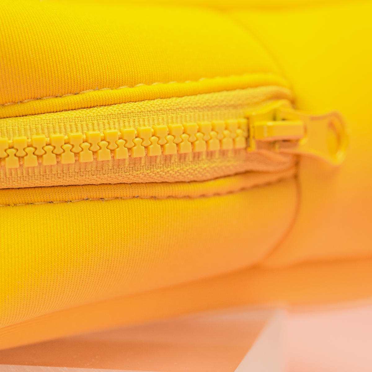 Nahaufnahme eines gelben Reißverschlusses auf der gelben Stoffoberfläche der PURISH Bag.