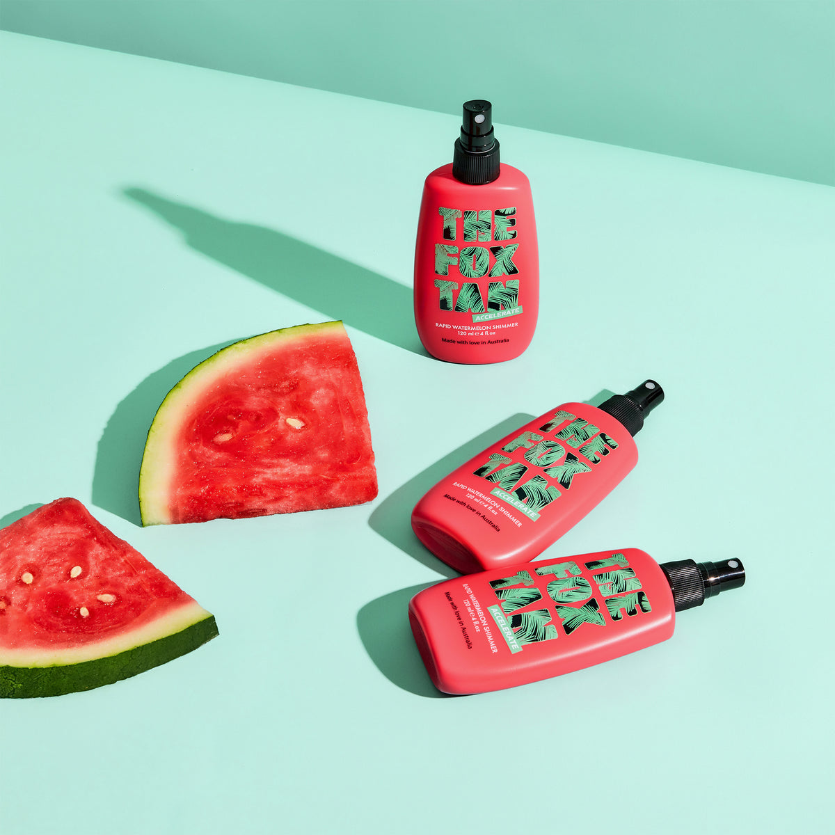 Drei Flaschen Rapid Watermelon Shimmer mit fettem Text stehen vor zwei Wassermelonenscheiben auf einem mintgrünen Hintergrund.
