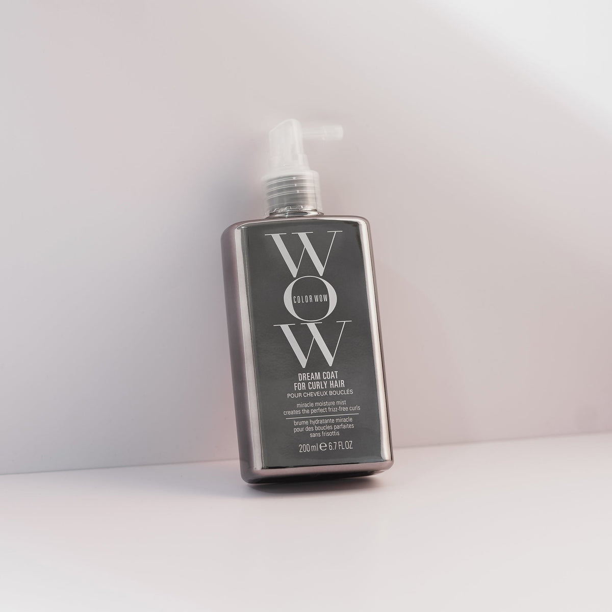 Eine Flasche Dream Coat for Curly Hair lehnt an einem hellen Hintergrund.