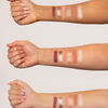 Drei Arme mit unterschiedlichen Hauttönen zeigen jeweils Swatches von sechs matten und schimmernden Lidschattentönen aus der Unconditional Palette.