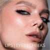 Nahaufnahme einer Frau mit auffälligem Make-up, Lidstrich und nudefarbenen Lippen, kreiert mit dem Crayon Lipliner Rosy Nougat von LH Cosmetics. Text: Lips | Eyes | Cheeks.