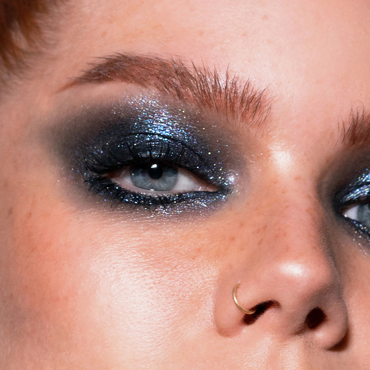 Nahaufnahme eines Gesichts mit metallisch blauem Lidschatten aus der Basic Elements Palette von LH Cosmetics.