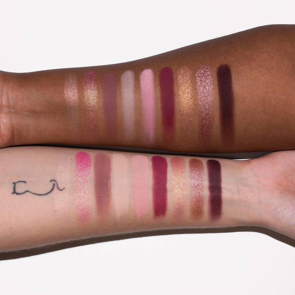 Zwei Arme mit unterschiedlichen Hauttönen zeigen Farbmuster in schimmernden und matten Rosa-, Gold- und Brauntönen aus der Blomma Palette von LH Cosmetics.
