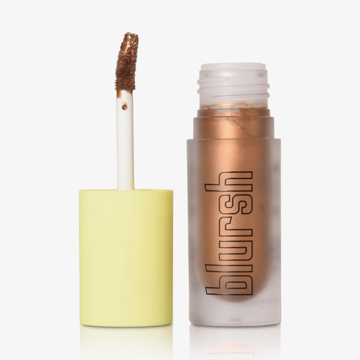 Eine geöffnete Tube von Made by Mitchell Blursh Lights Metallic Liquid Make-up, mit dem Applikatorstab neben der mattierten Flasche.