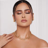 Frau mit geschlossenen Augen, Goldschmuck und zurückgekämmtem Haar, präsentiert vor hellem Hintergrund ein Nude-Make-up, das mit der Essential Palette kreiert wurde.