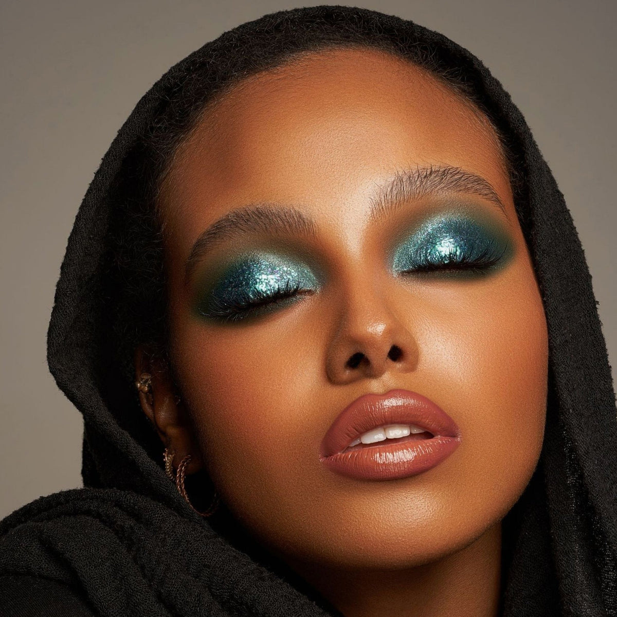 Person mit geschlossenen Augen und mittlerem Hautton präsentiert schimmernden, irisierenden Make-up-Look mit den Infinite Chrome Flakes Laser Beam.