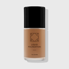 OFRA Liquid Foundation in der Nuance Deep in transparenter Glasflasche mit schwarzem Deckel und schwarzer Beschriftung, vor hellem Hintergrund.