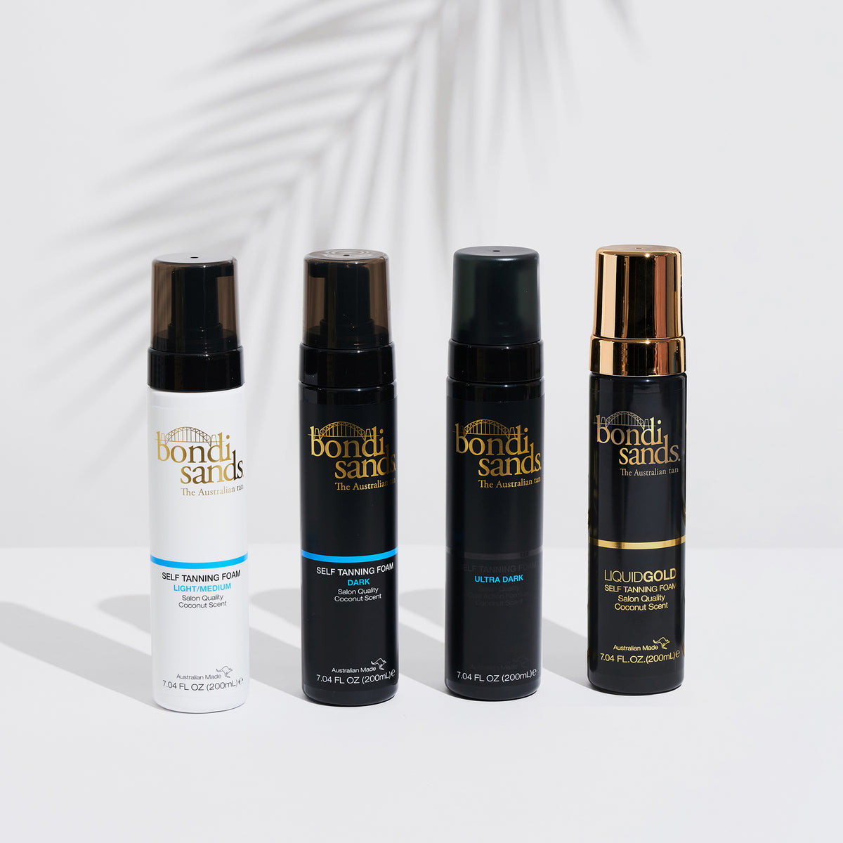 Vier unterschidliche Flaschen Bondi Sands Self Tanning Foam mit Palmblattschatten im Hintergrund