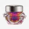 Transparenter Tiegel Infinite Chrome Flakes Superstar mit bunt schillerndem Inhalt und silbernem Deckel vor weißem Hintergrund.