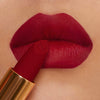 Der Matte Pleasure Lipstick in der Farbe Signature Red auf den Lippen aufgetragen – Nahaufnahme mit samtig-mattem Finish.
