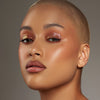 Person mit geschlossenen Augen und mittel-hellem Hautton präsentiert schimmernden, irisierenden Make-up-Look mit den Infinite Chrome Flakes Monarch.